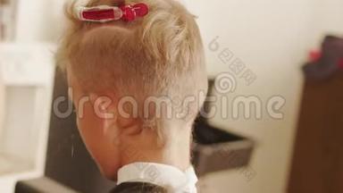 理发店的理发师在理发店里剪着少年头发